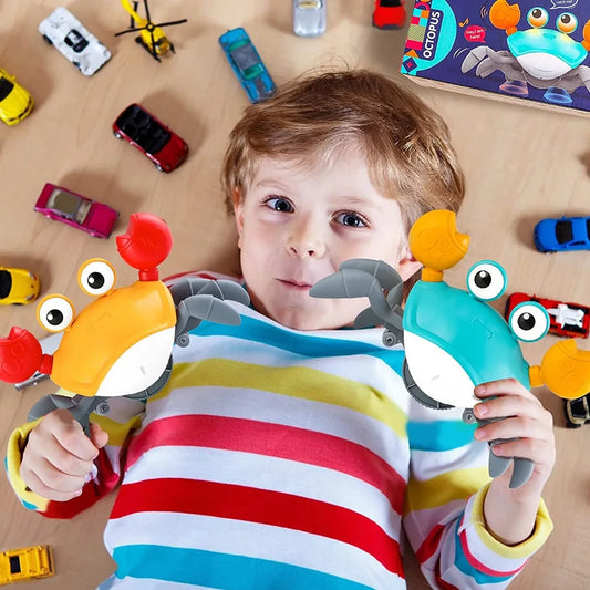 Smiling child holding two colorful interactive crawling crab toys with lights.