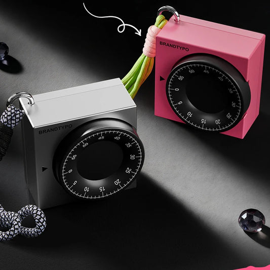 Two square visual timers, one silver and one pink, with black rotary dials and lanyards.