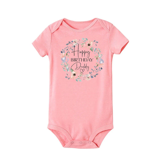 Pink short-sleeve baby bodysuit with "Happy Birthday Daddy" in a floral wreath design.