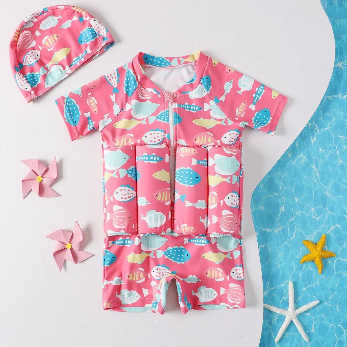 Pink kids' floatation swimsuit with colorful fish print and matching swim cap.