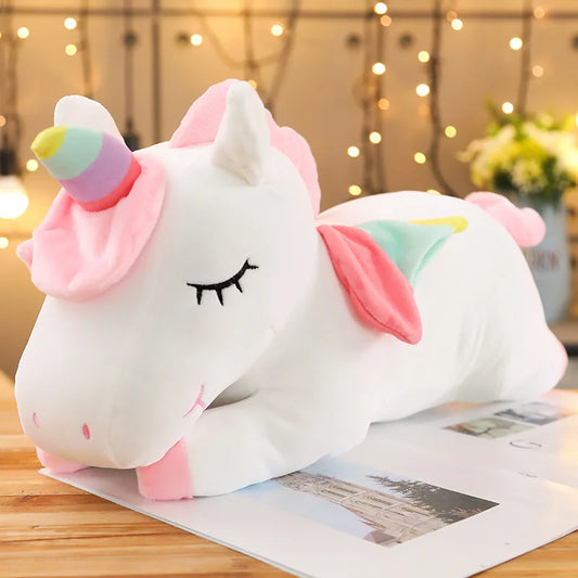 Soft white plush unicorn toy with pink mane, rainbow horn, and pastel wings.