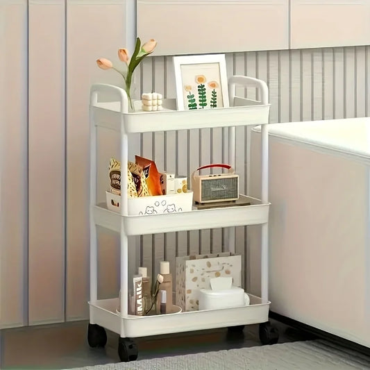 White 3-tier plastic storage cart with wheels, holding snacks, toiletries, and decor.