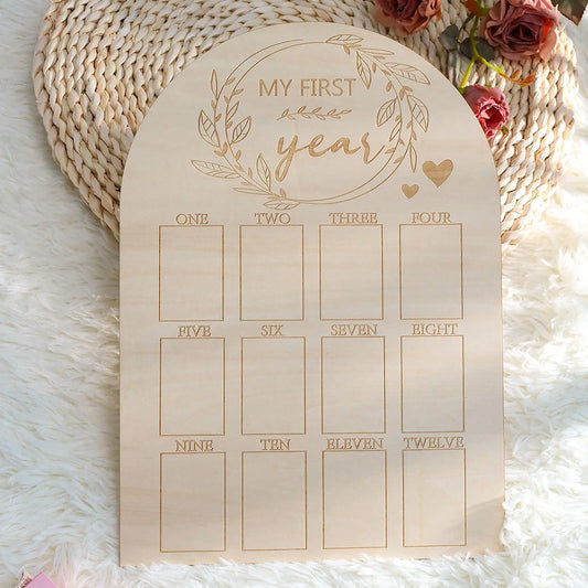 Arched natural wood baby milestone board, "MY FIRST year" engraved, with 12 monthly photo slots.