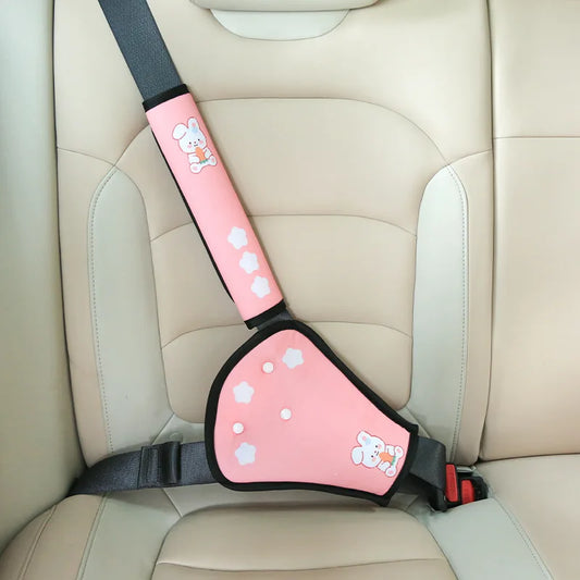 Pink child car seat belt adjuster with cute bunny and star designs on a beige car seat.