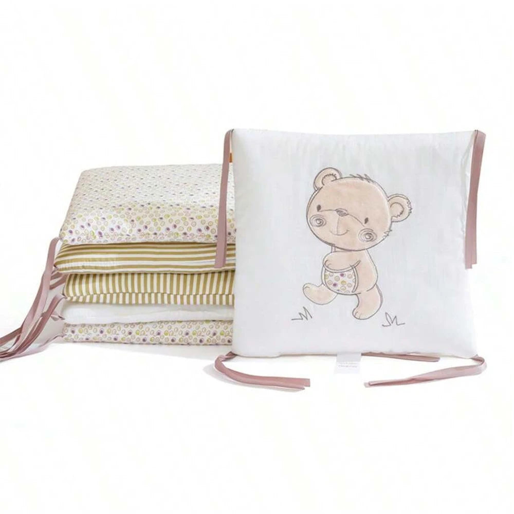 White cotton crib bumper set with a cute teddy bear design and pink ties.