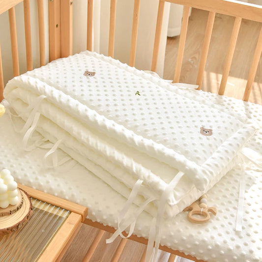 Soft white polyester crib bumper with raised dots and embroidered cartoon bears.