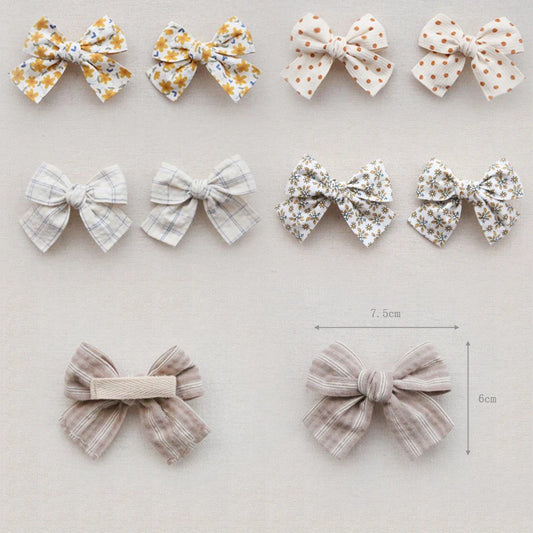 Collection of cotton hair bows for girls in various floral, polka dot, and plaid patterns.