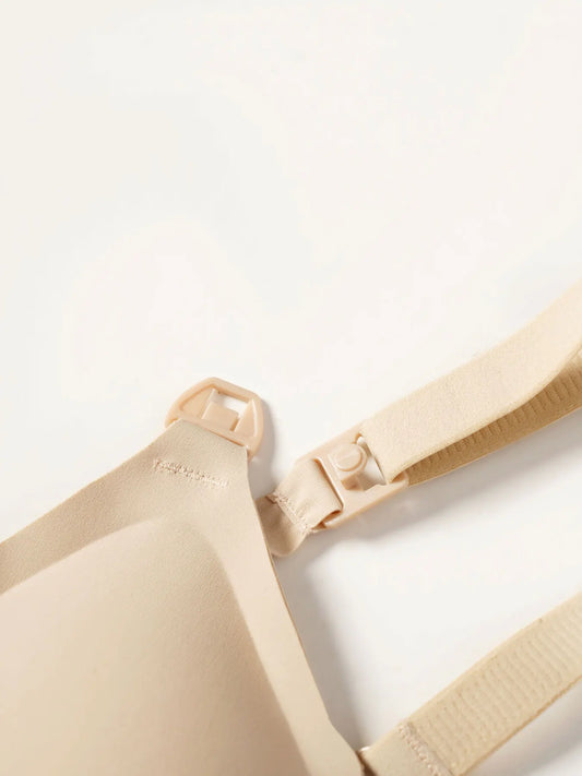 Beige wireless V-neck nursing bra with easy-open clip and adjustable strap, made of nylon-spandex blend.
