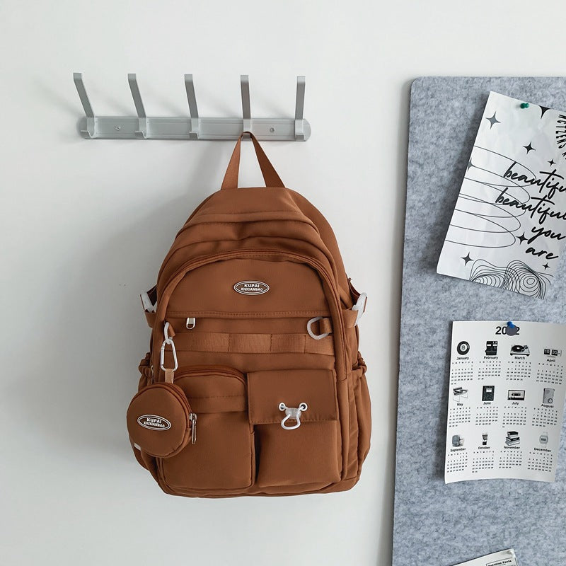 Brown nylon student backpack with laptop compartment, multiple pockets, and a matching coin pouch.