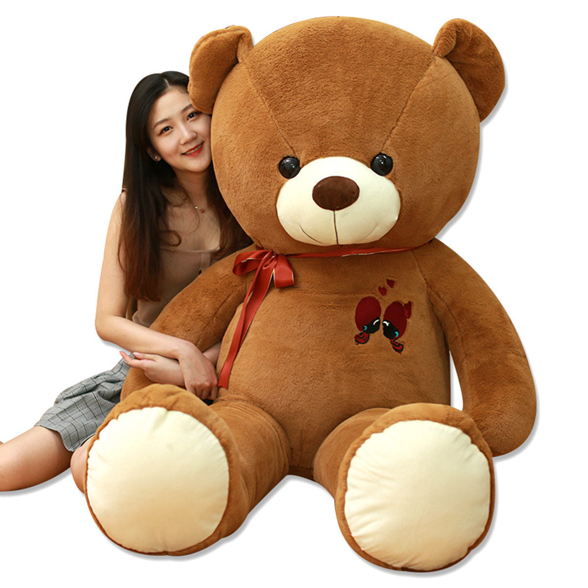 Large brown plush teddy bear with a red ribbon, featuring embroidered hearts and two small birds.