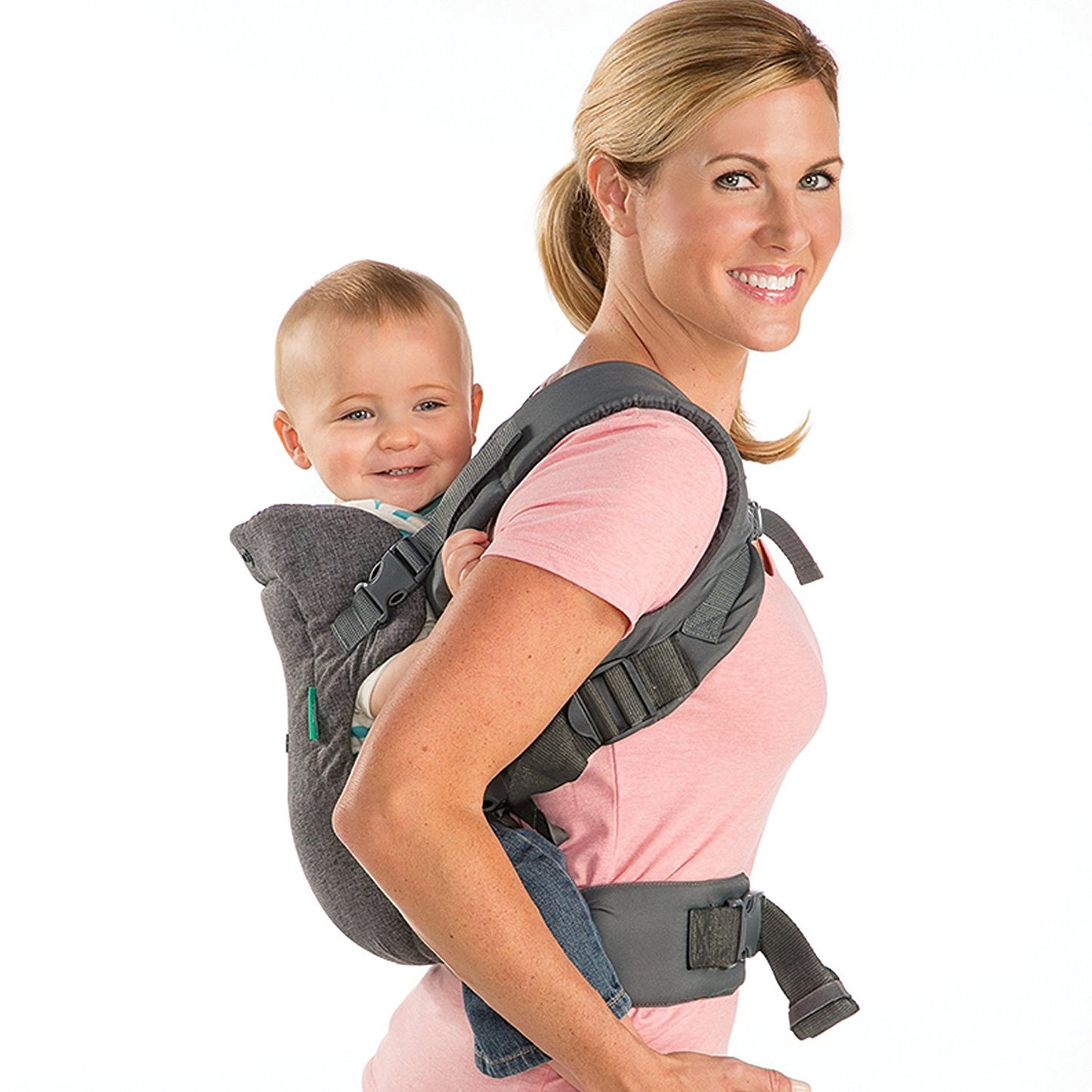 Smiling mom carrying a happy baby in a gray ergonomic, adjustable, and breathable baby carrier.
