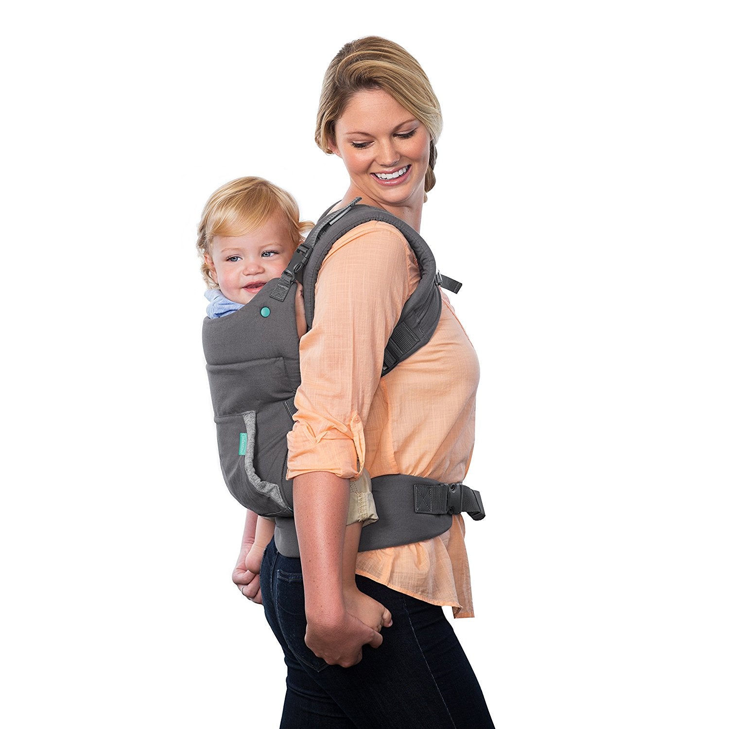 Smiling woman carrying a happy baby in a gray ergonomic, breathable baby carrier on her back.