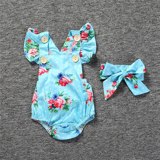 Blue chiffon sleeveless baby romper with white polka dots, red and blue floral print, wooden buttons, and matching bow headband.