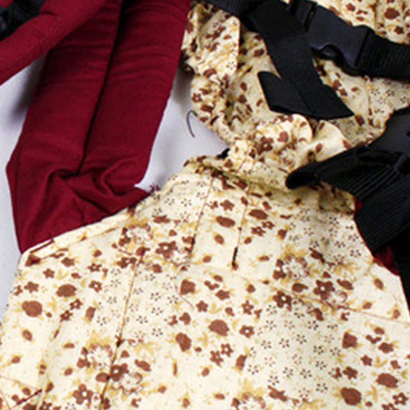 Ergonomic cotton baby carrier with a cream floral pattern and maroon padded straps.