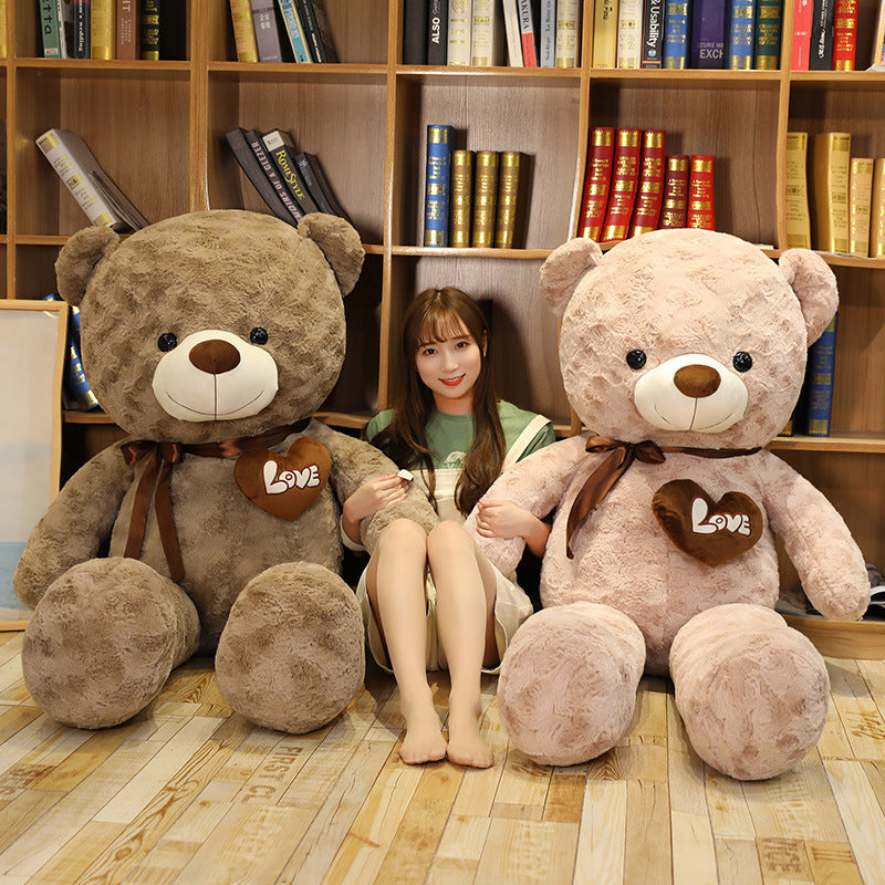 Giant plush teddy bears in brown and pink with "LOVE" hearts, flanking a young woman.