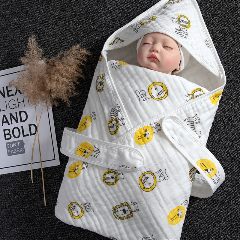 White cotton gauze baby swaddle with yellow lion print, hood, and velcro closure.