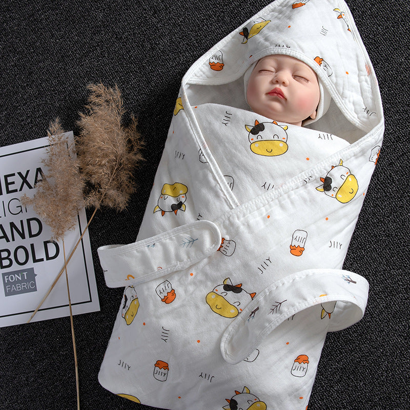 White cotton gauze baby swaddle with cute cow print, featuring a hooded design and velcro closure.