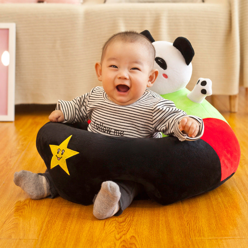 Happy baby in a plush black, red, and green panda-themed support seat with a yellow star.
