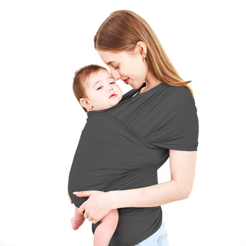 Mother holding baby in a dark gray soft ergonomic cotton baby wrap carrier.