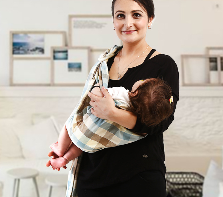 Woman holding a baby in a soft, breathable plaid cotton baby sling carrier.