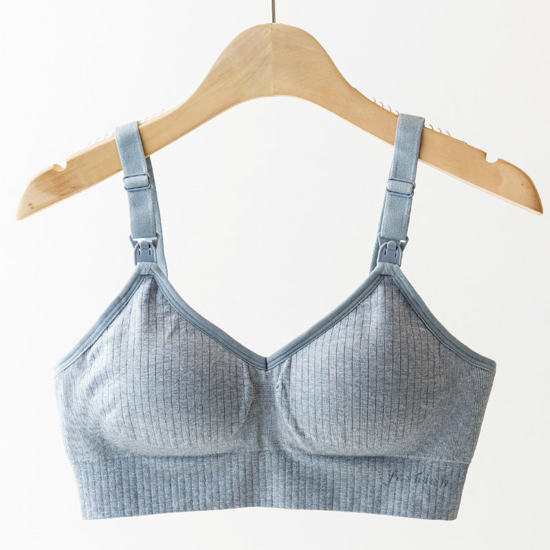 Light blue ribbed wireless nursing bra on a wooden hanger, featuring adjustable straps and clips.