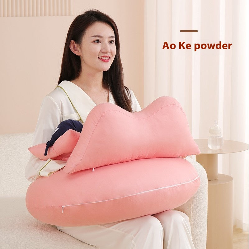 Smiling woman holding a pink, multi-functional nursing pillow with a smaller support pillow.