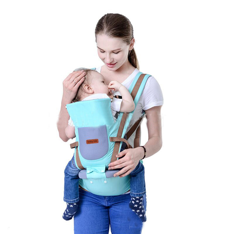 Woman carrying baby in a turquoise ergonomic baby carrier with brown straps and waist seat.
