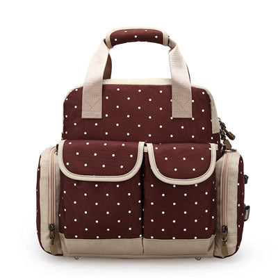 Brown polka dot diaper backpack with beige trim, top handles, and multiple front pockets.