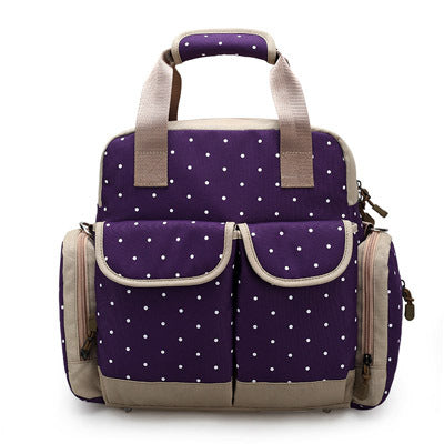 Purple polka dot diaper backpack with beige trim, multiple pockets, and top handles.