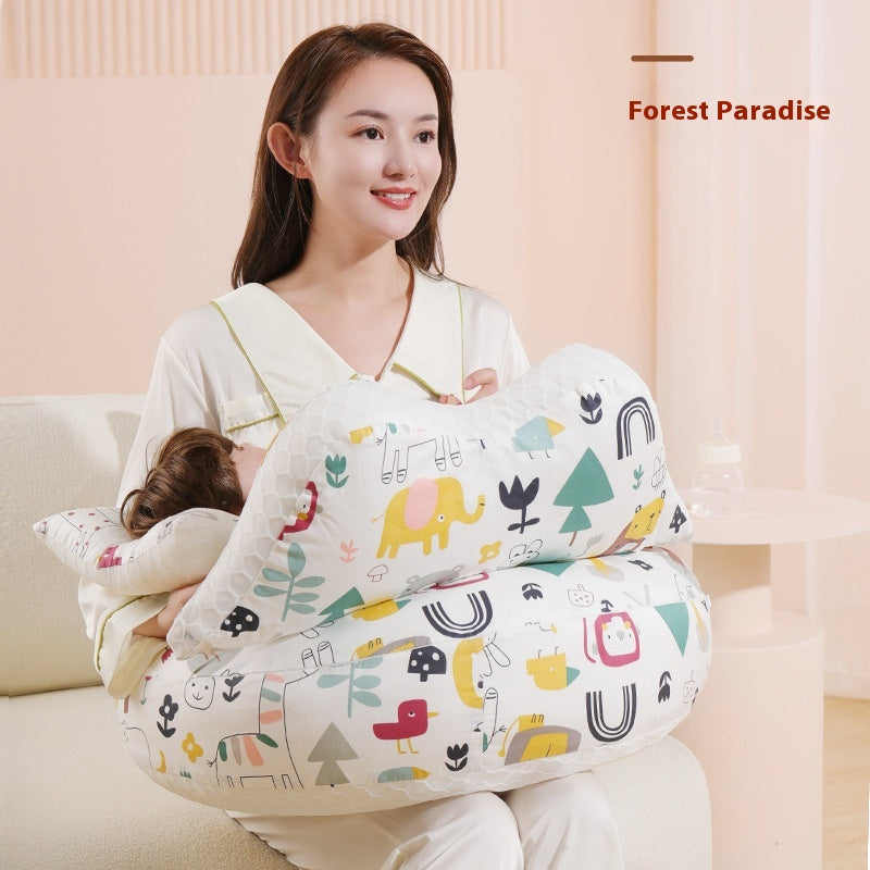 Smiling woman holding a baby with a white multi-functional nursing pillow featuring colorful animal and nature prints.
