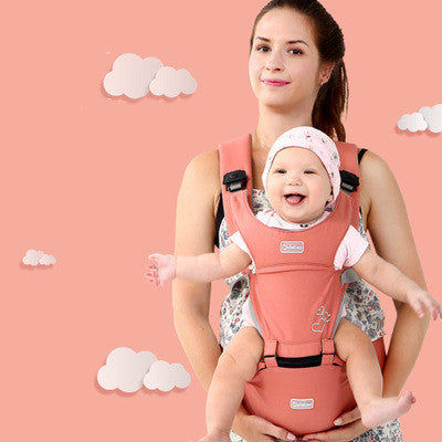 Mother carrying a smiling baby in a salmon pink ergonomic baby carrier with a supportive waist seat.