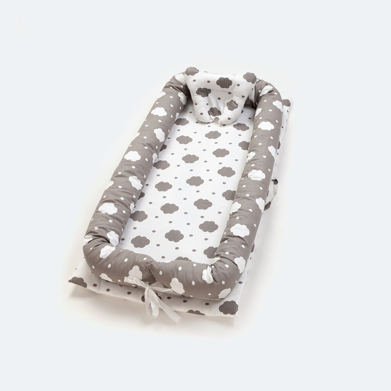 Portable cotton baby nest with grey cloud pattern, head protector, and ties.