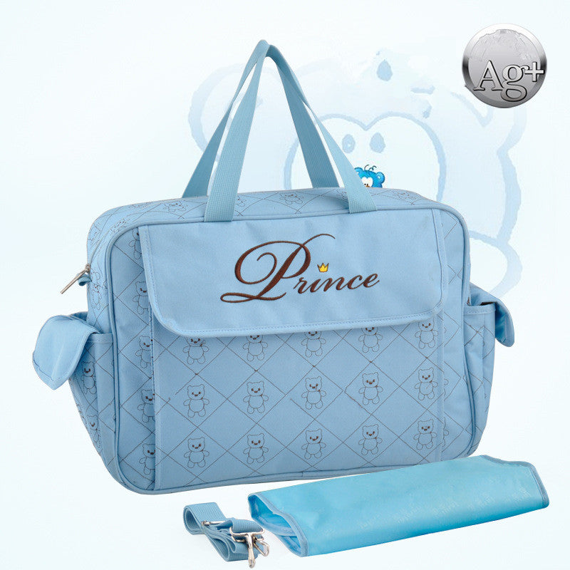Light blue "Prince" diaper bag with bear pattern, includes changing pad and shoulder strap.