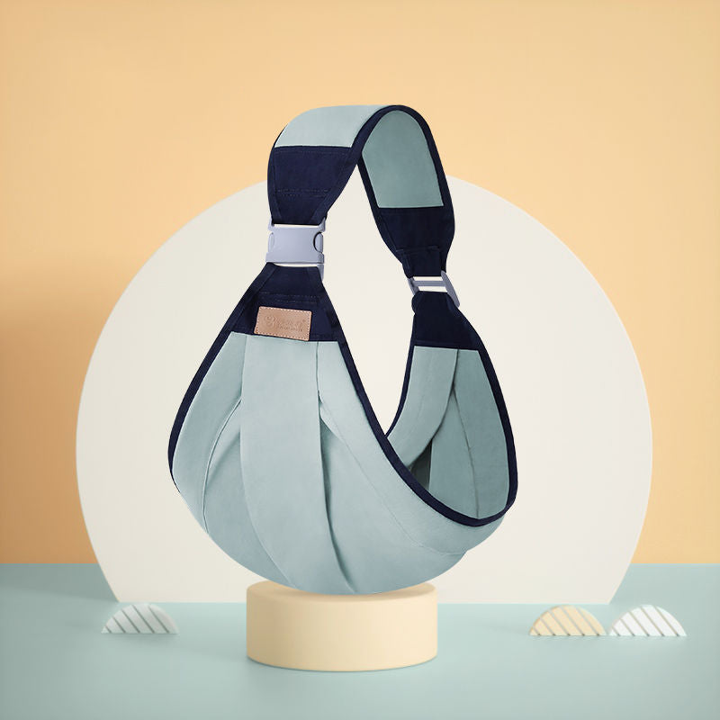 Ergonomic baby carrier in light blue and navy, featuring a single shoulder strap and adjustable buckle.