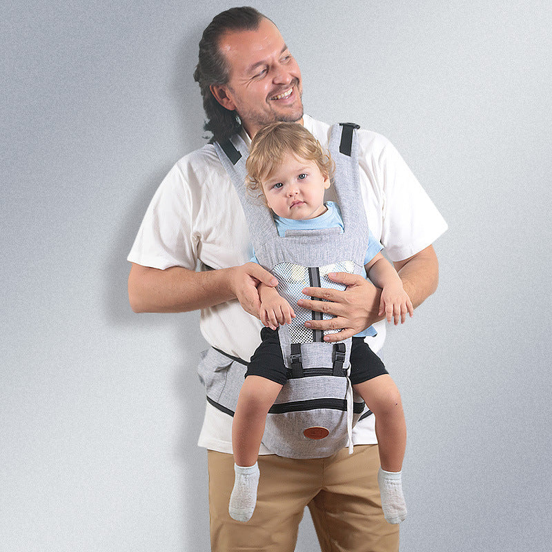 Man wearing a gray ergonomic baby waist carrier with a baby, featuring breathable mesh and secure straps.