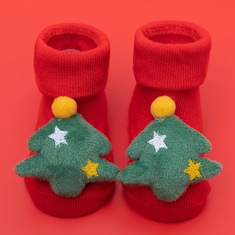 Red cotton baby socks with green Christmas tree appliques and anti-slip soles.