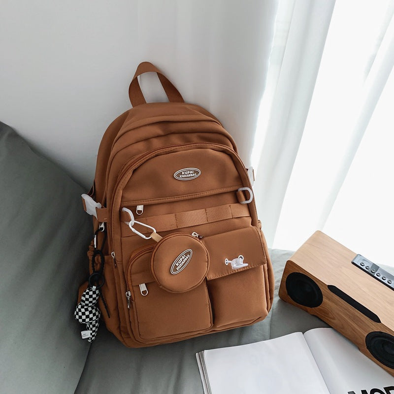 Brown nylon student backpack with laptop compartment, multiple pockets, and small round pouch.