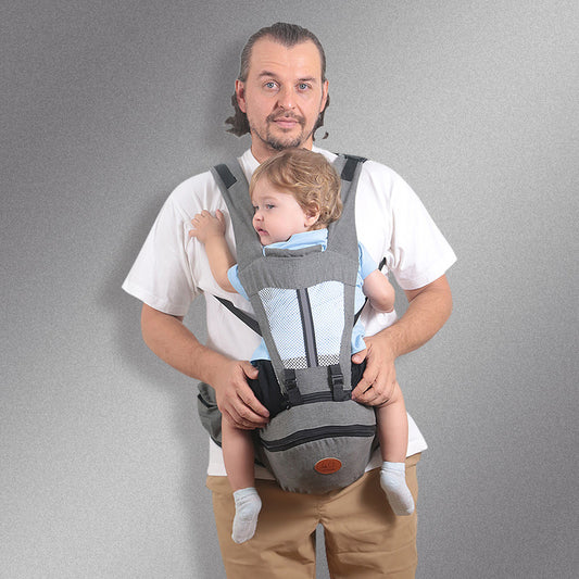 Man wearing a gray ergonomic baby hip carrier with mesh panel, holding a toddler.