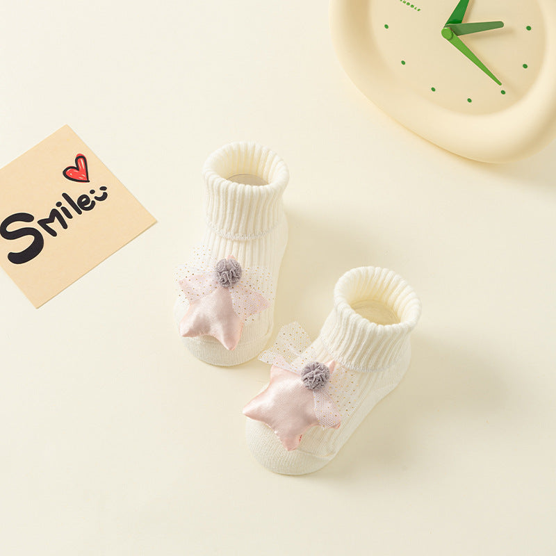 White cotton baby socks with pink star and pom-pom details, anti-slip soles, for ages 0-3.