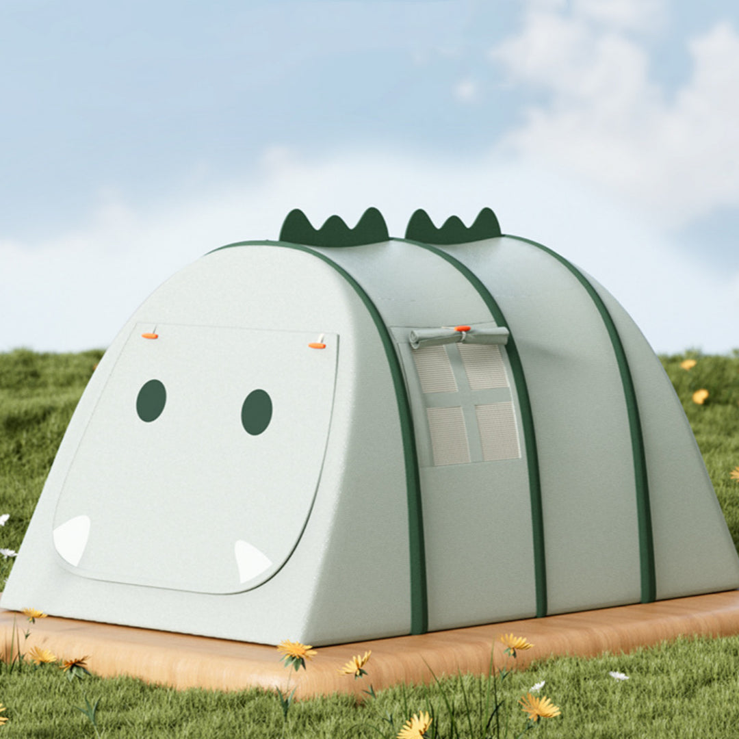 Green fabric kids' play tent shaped like a crocodile, with dark green accents and a window, on a wooden base in grass.