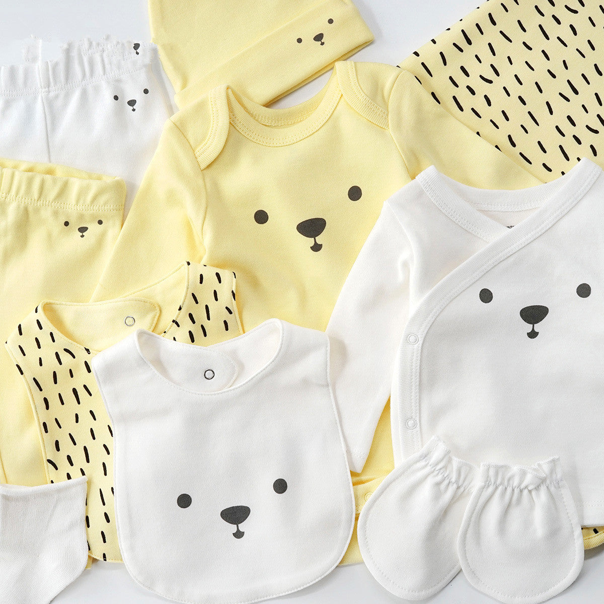 10-piece yellow and white organic cotton baby set with bear and chick designs.