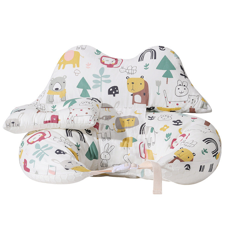 White multi-purpose nursing pillow with colorful animal and nature prints, featuring a safety strap.