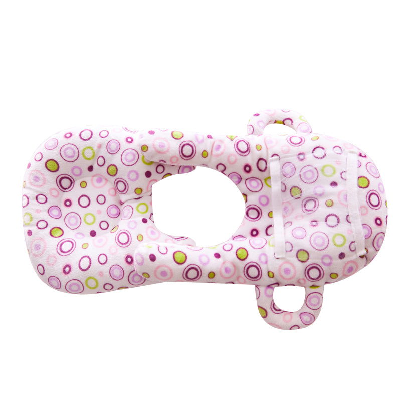 Pink velvet baby nursing and feeding pillow with colorful circle pattern.