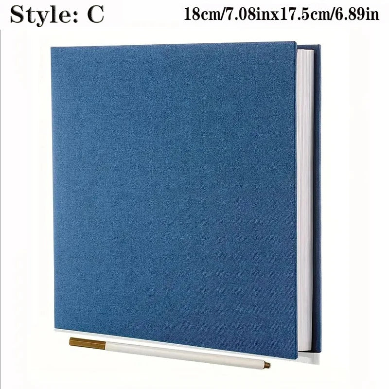 Blue linen fabric self-adhesive photo album with spiral binding, shown with a white marker.