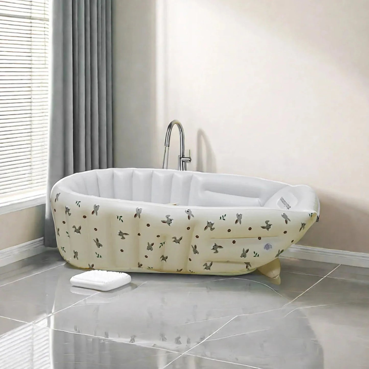 Portable inflatable baby bathtub with built-in pump, cream PVC, animal print design.