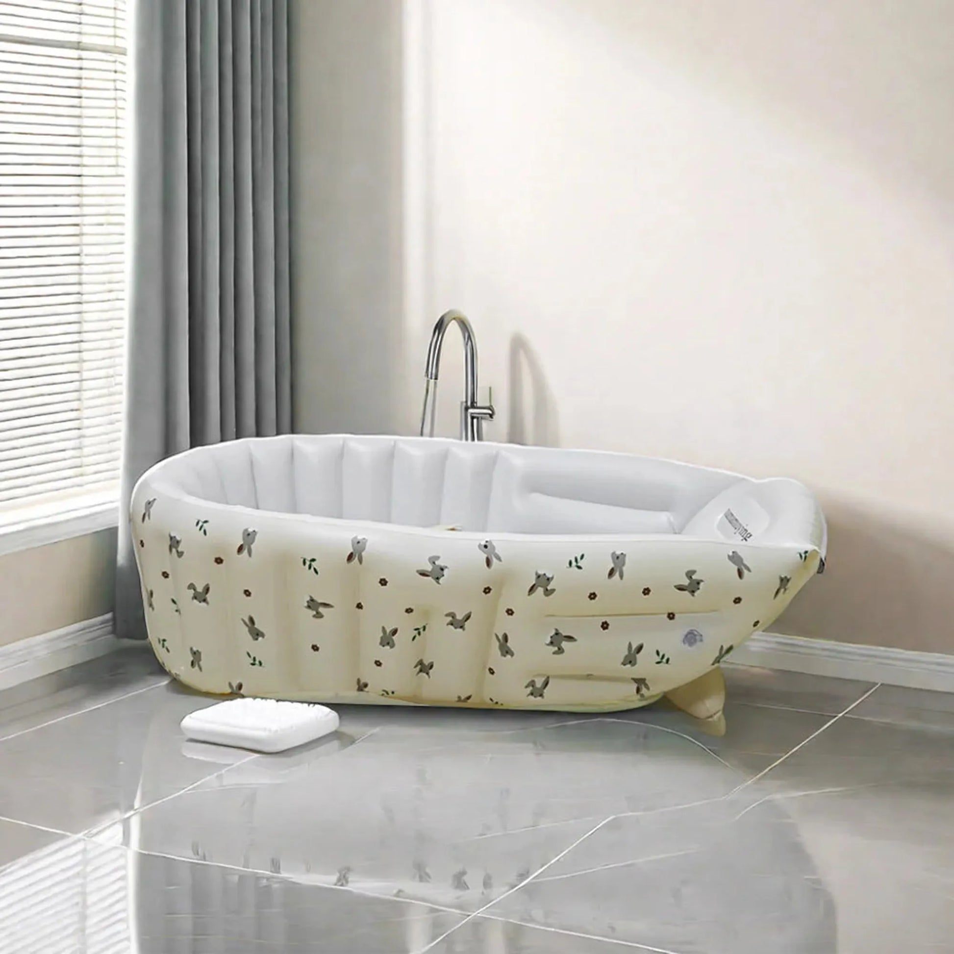 Portable inflatable baby bathtub with built-in pump, cream PVC, animal print design.