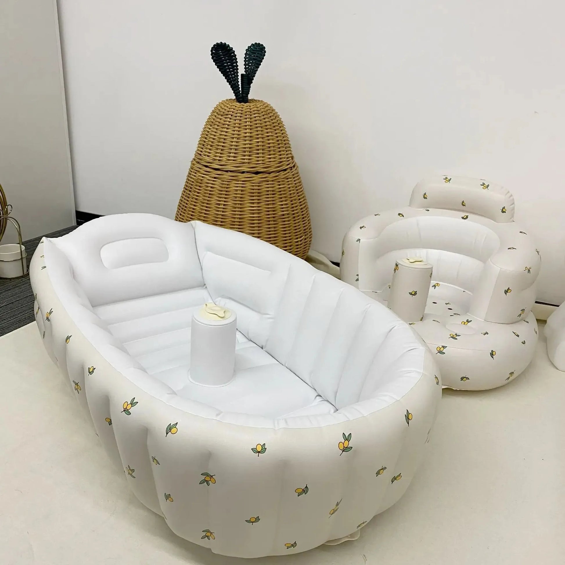 White inflatable baby bathtub with lemon print and built-in pump, next to a matching inflatable seat.