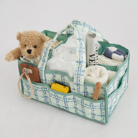 Portable baby diaper caddy organizer with blue and green plaid fabric, multiple compartments, and handles.