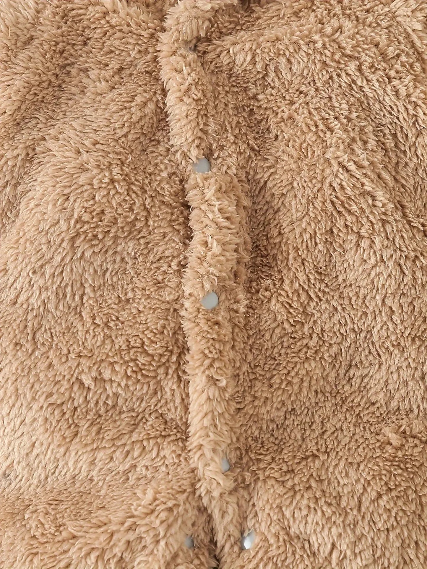Close-up of a soft, fluffy beige fleece baby romper with snap buttons.