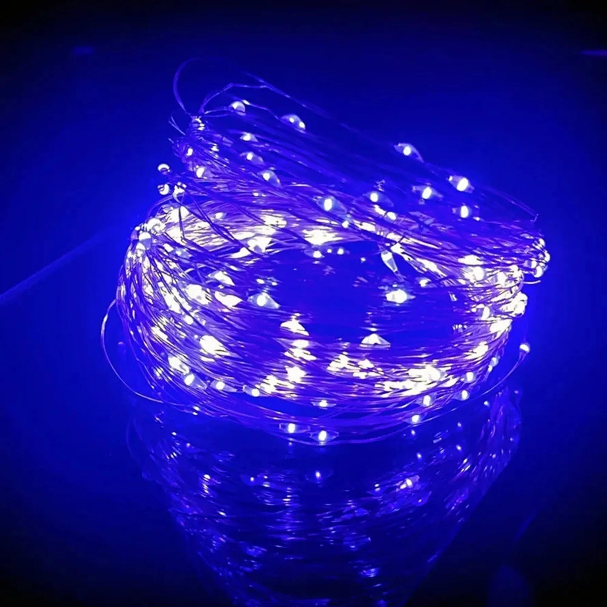 Coiled blue LED string lights on a reflective surface, glowing brightly.